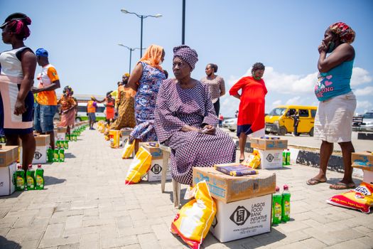 Women Outdoors with Food and Home Essentials Aid Packages