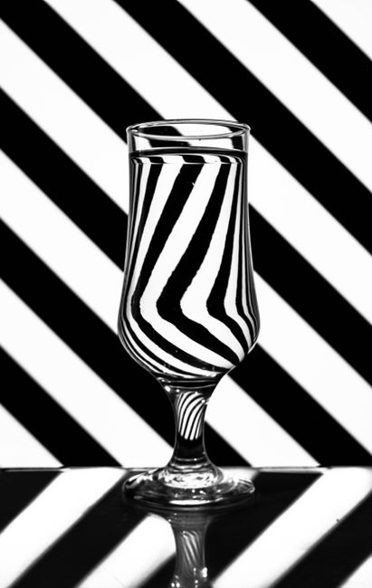 Creative glass reflection with abstract black and white stripe pattern background, studio shot.