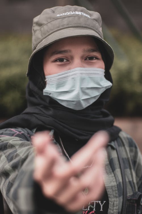 Young Man Wearing a Face Mask Reaching His Hand Towards the Camera 