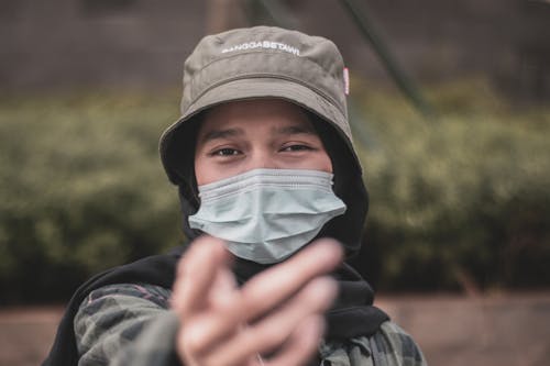 Person in Brown Bucket Hat Wearing Face Mask