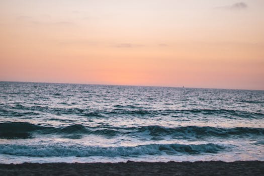Calm waves and a vibrant sky at sunset on Hermosa Beach, CA.