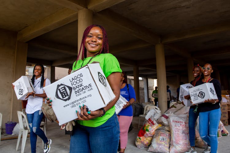 Happy Volunteers Carrying Boxes