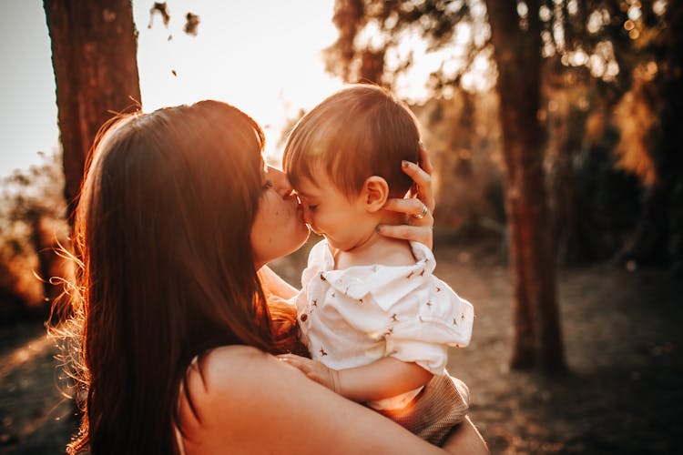 A Woman Kissing A Young Boy