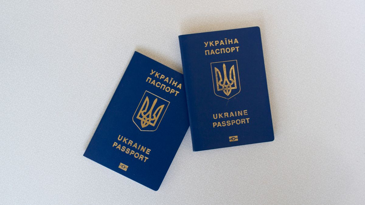 Two Ukrainian passports placed on a white surface in a flat lay style.