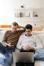 Man in White Sweater Sitting Beside Man in Brown Sweater
