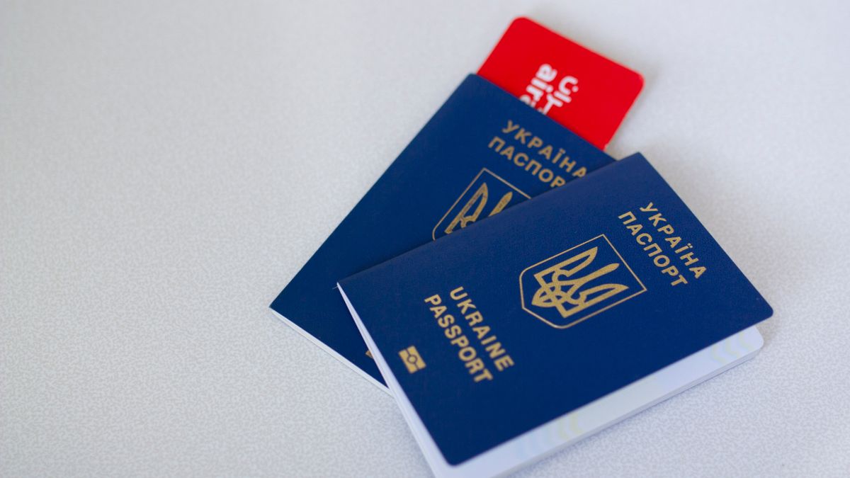 Close-up of Ukrainian passports and travel card on a light surface with ample copy space.