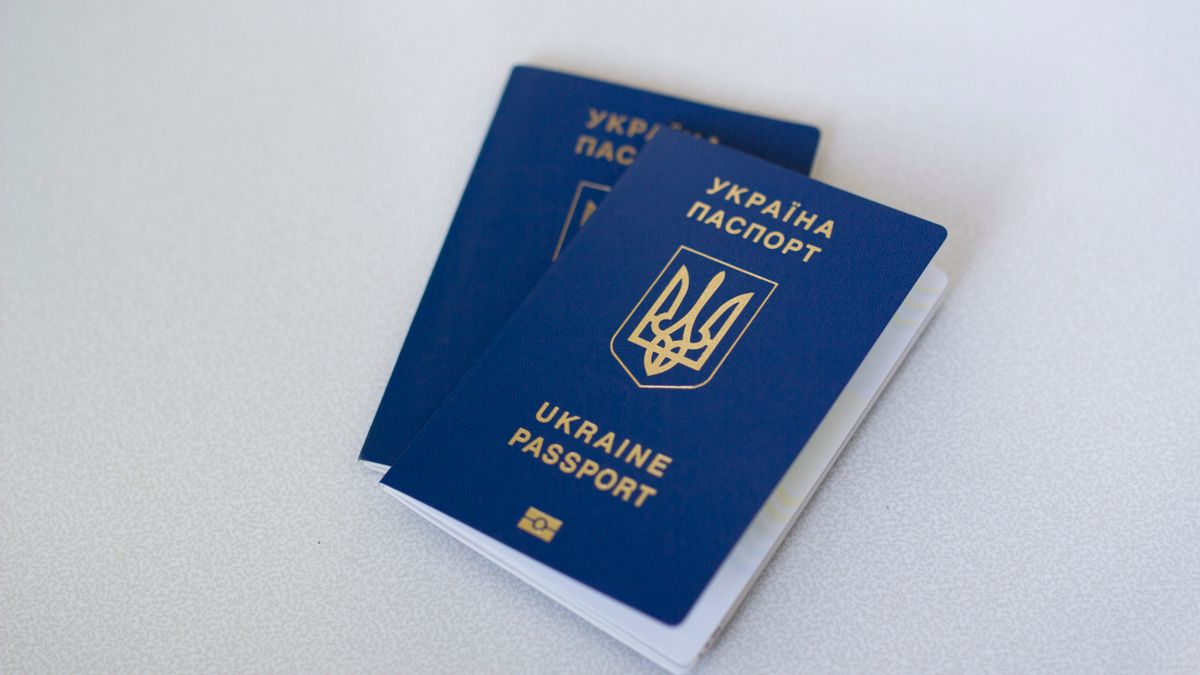 Blue Ukrainian passports on a light surface, highlighting travel documents.