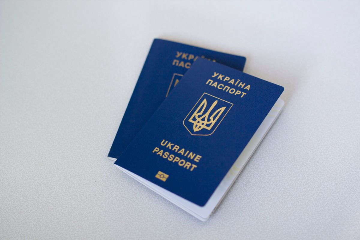 Two passports laid on a white desk