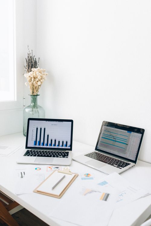 Free A bright office setup featuring laptops, charts, and paperwork for business analysis. Stock Photo