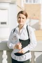 Woman in White Dress Shirt and Black Vest Holding White Printer Paper