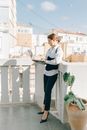 Woman in White Long Sleeve Shirt and Black Pants Standing on White Concrete Staircase