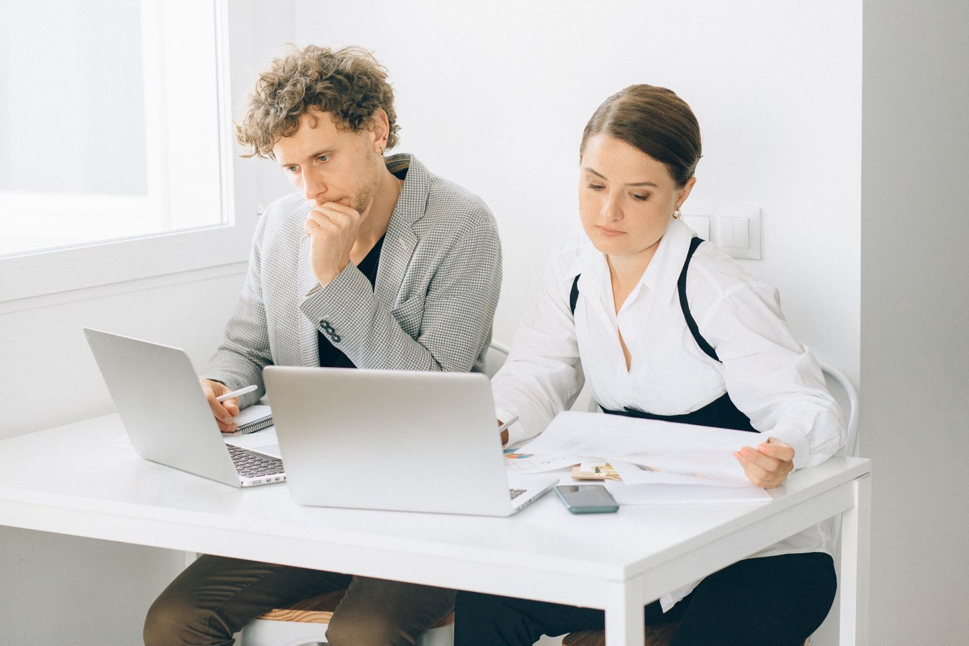 Professionals using laptops in a bright workplace