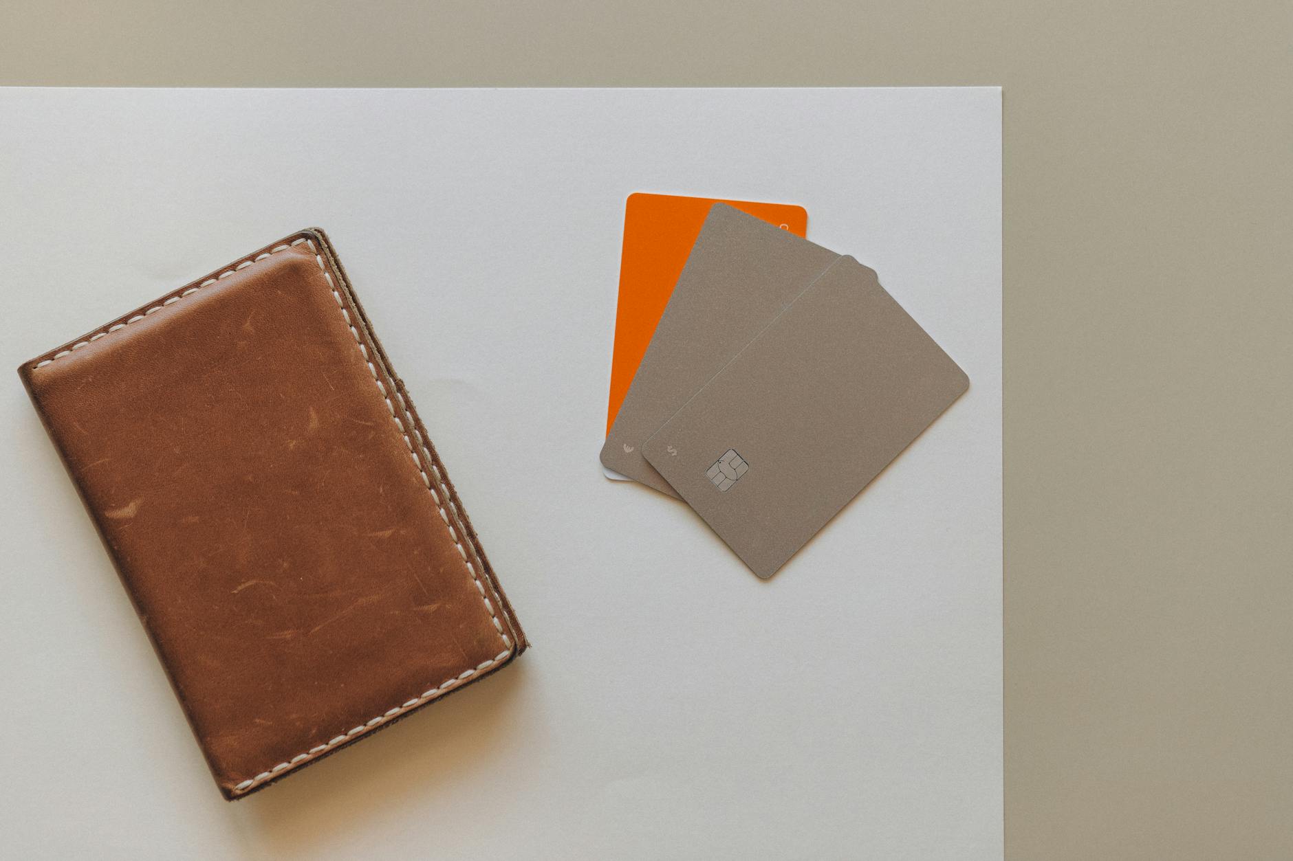A leather wallet and credit cards on a minimalist background