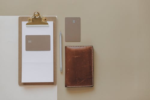 Free Brown Leather Wallet on Beige Surface Stock Photo