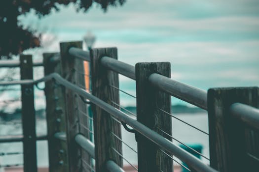 Wooden and steel handrails on a coastal boardwalk with serene ocean backdrop.