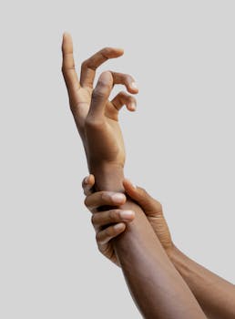 A close-up of two intertwined hands on a neutral gray background symbolizing connection.