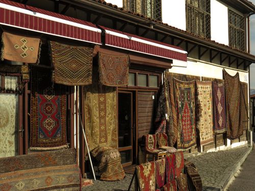 Free A display of vibrant handmade rugs hanging outside a traditional shop in Ankara, Türkiye. Stock Photo