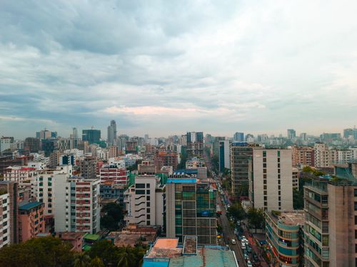 Free Aerial view capturing Dhaka's bustling urban landscape with high-rise buildings under a cloudy sky. Stock Photo