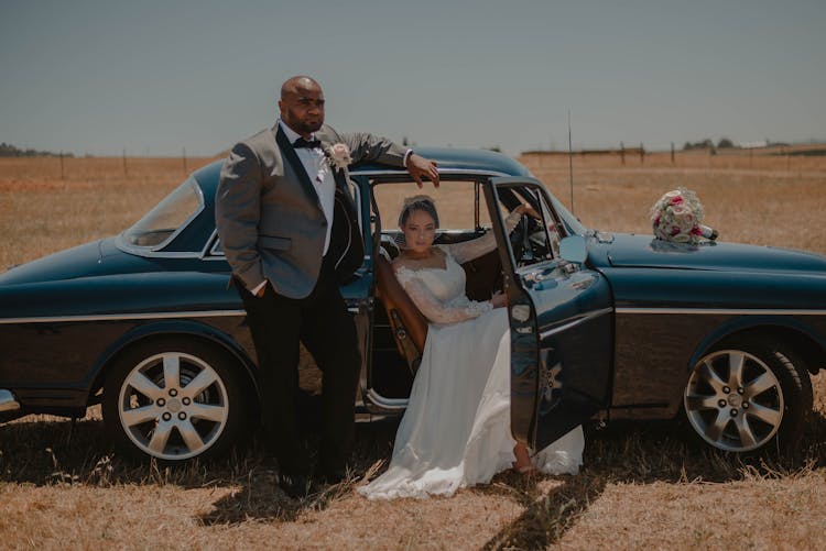 Newlyweds Posing By Car