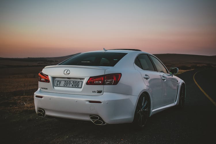 White Lexus Car Parked On The Side Of An Asphalt Road