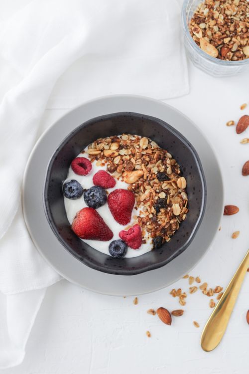 Free Delicious breakfast bowl with yogurt, fresh berries, and granola on a white surface. Stock Photo