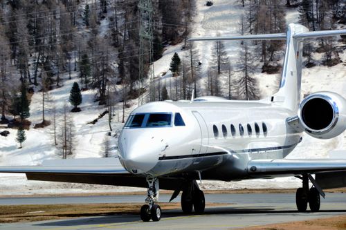 Free A sleek private jet taxiing on a snowy runway with mountainous backdrop in Samaden, Switzerland. Stock Photo
