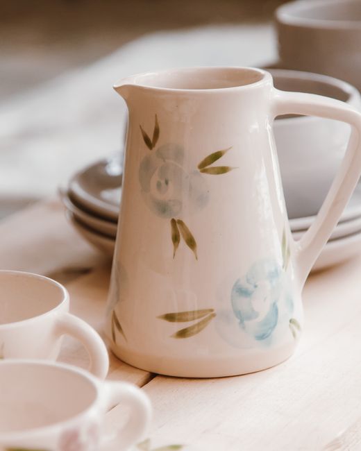 Fotomural Un primer plano de una jarra de cerámica con un delicado diseño floral, perfecta para la decoración del hogar.