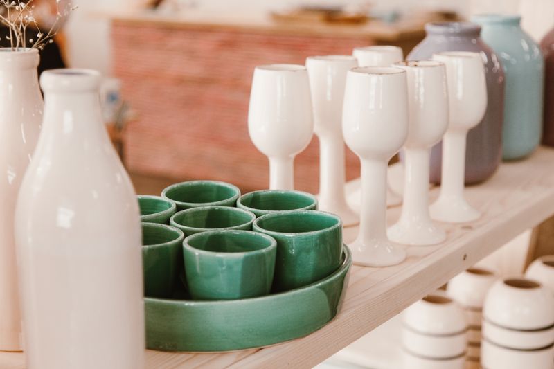 Rows of glazed stoneware vases in soft sage tones