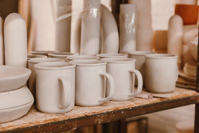 Unglazed ceramic mugs on a studio shelf, photo by ROMAN ODINTSOV on Pexels
