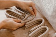 Person Holding White Textile on Brown Wooden Table