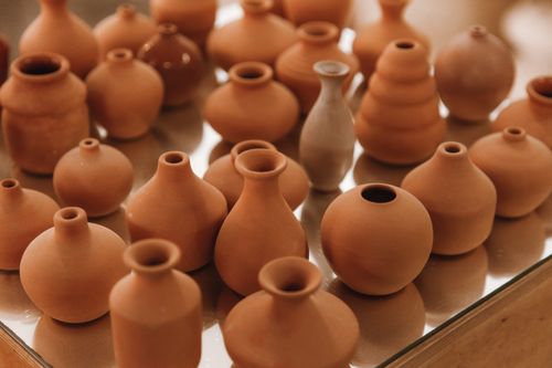 Free A variety of ceramic pottery displayed on a glossy surface, showcasing craftsmanship. Stock Photo
