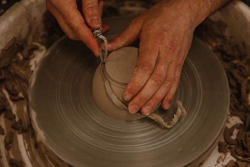 Free Detailed close-up of hands sculpting clay on a spinning pottery wheel, capturing the art of ceramics. Stock Photo