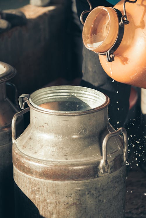 Close-up of Milk Being Poured into a Metal Container