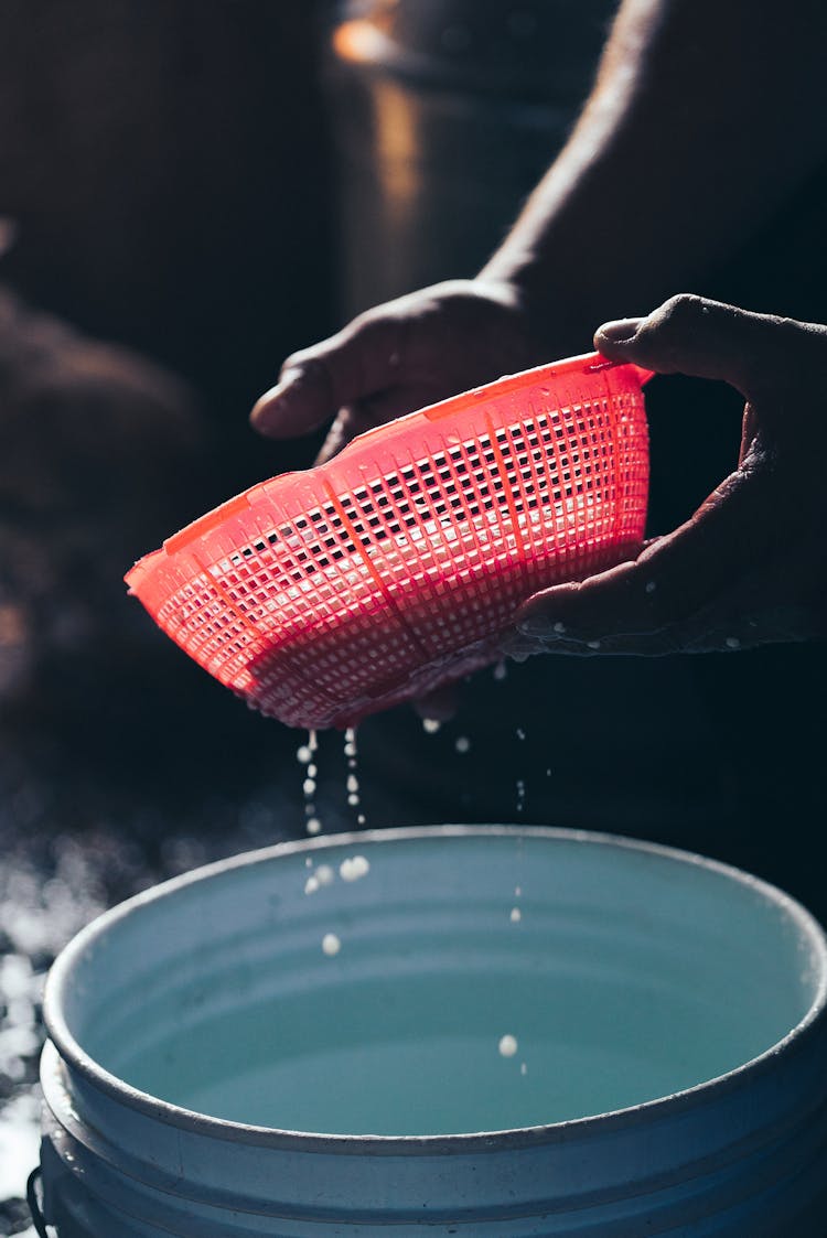 Person Squeezing Cottage Cheese In Colander