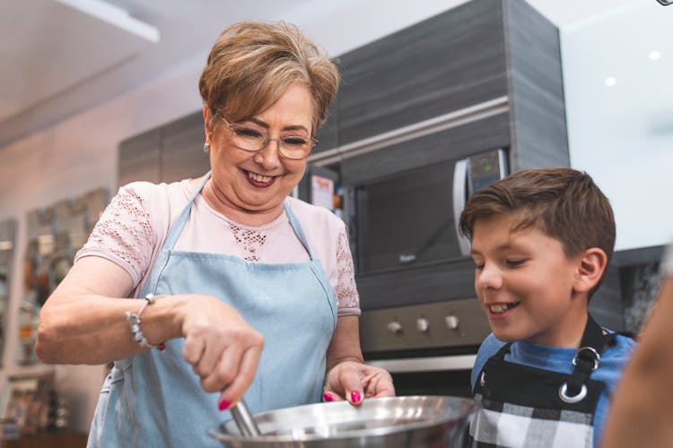 Woman In Pink Shirt And Blue Apron Cooking