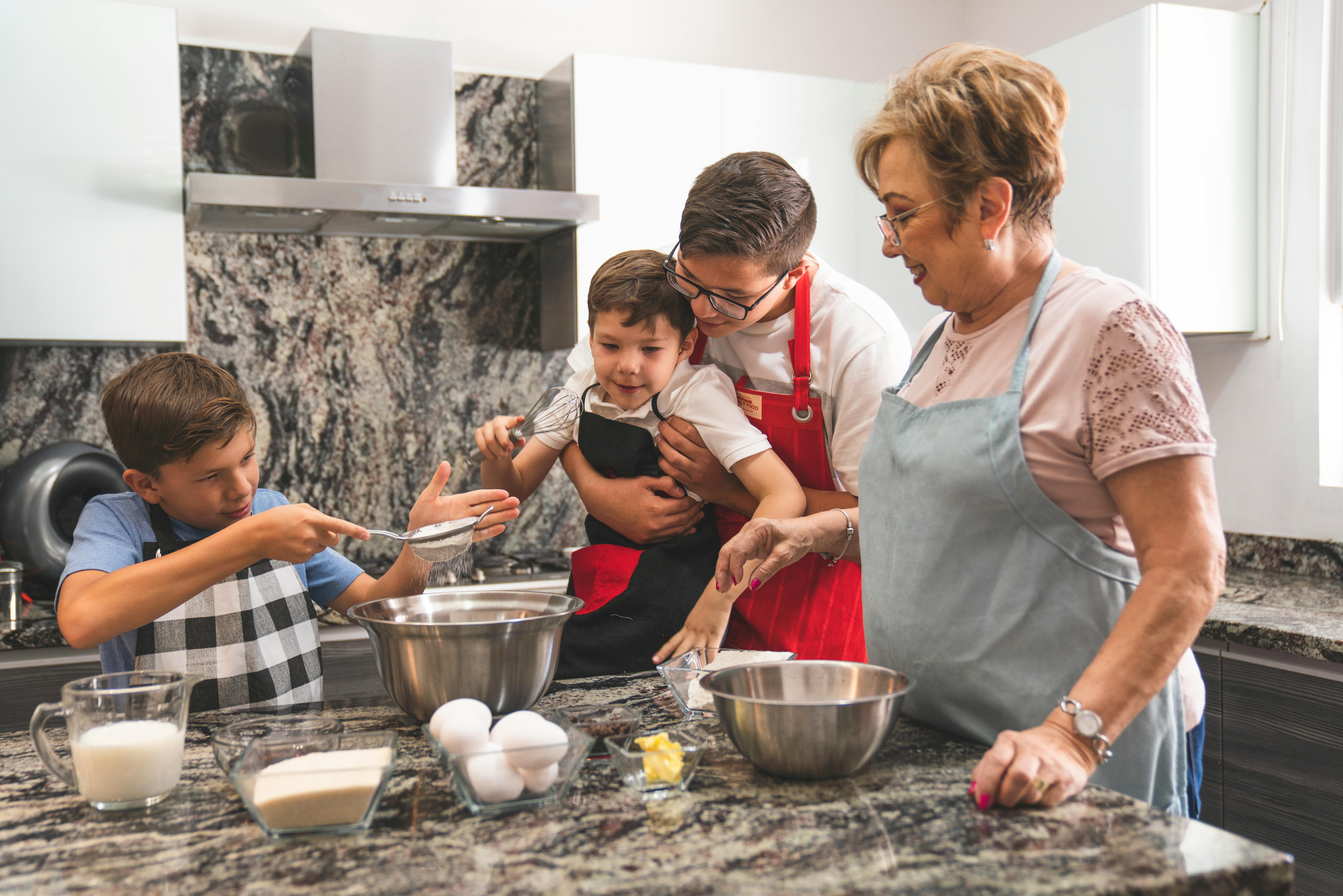 A multigenerational family baking and enjoying quality time in a modern kitchen.