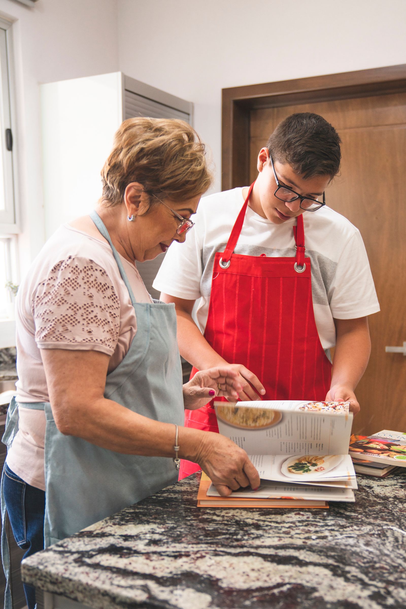 Un jeune et une personne âgée cuisinent ensemble à domicile