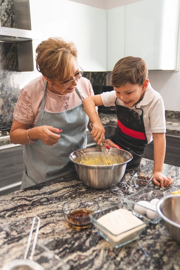 Grandma And Grandson Baking At The Kitchen