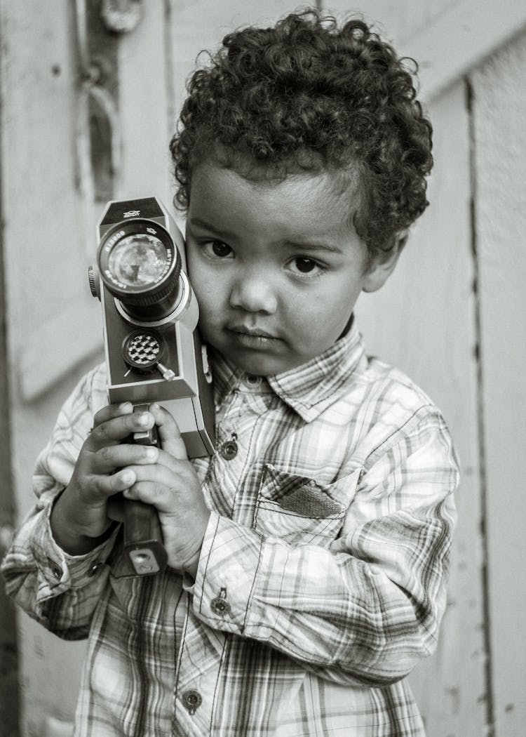 Little Boy Holding A Vintage Camcorder 