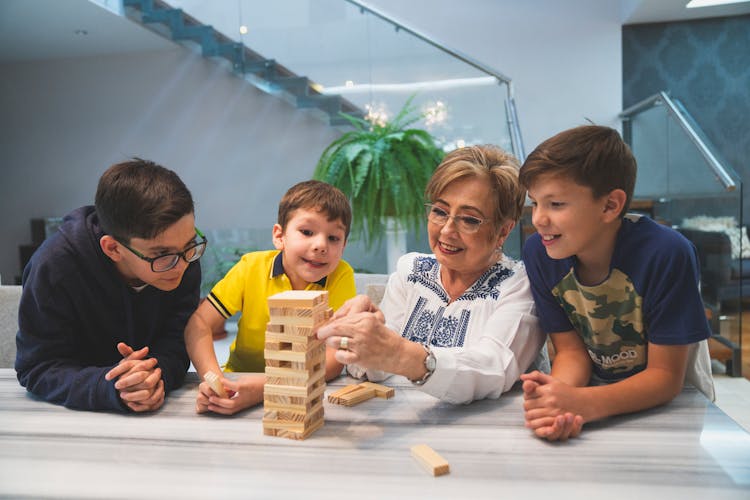 A Family Playing Jenga On The Table