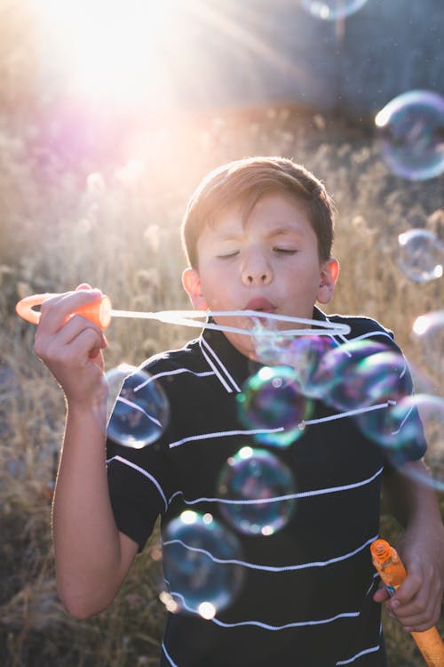 A Boy Blowing Soap Bubbles