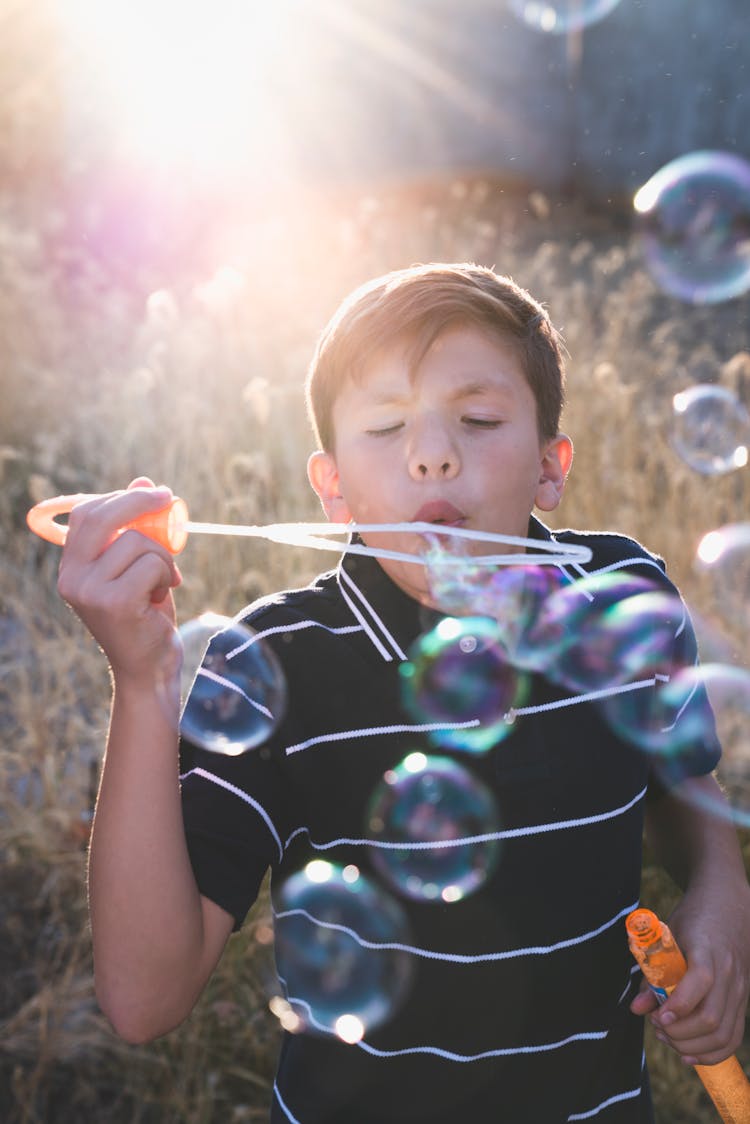 A Boy Blowing Soap Bubbles