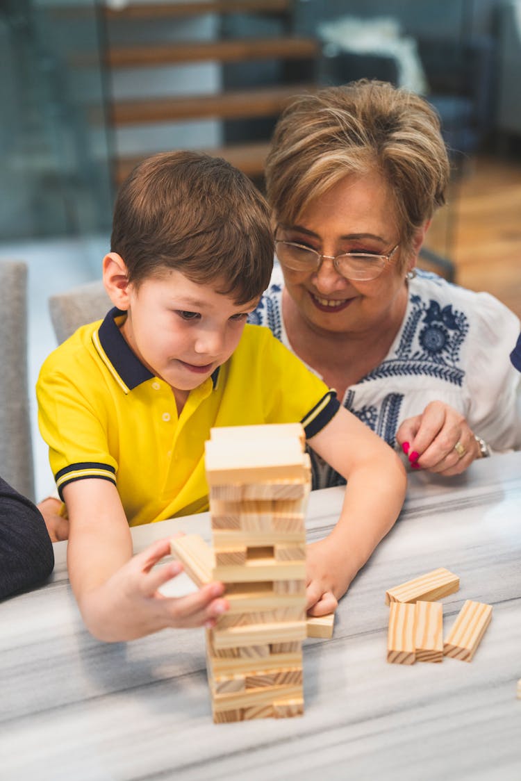 Grandma And Grandson Playing Jenga On The Table