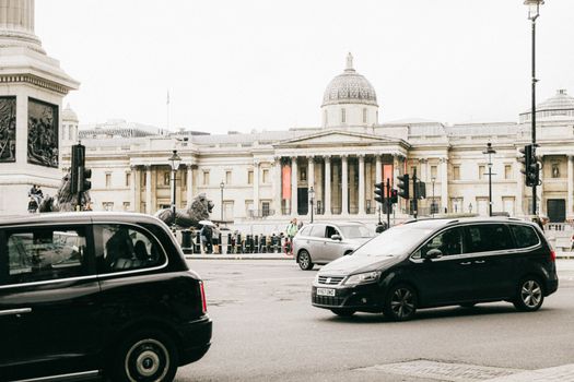 Street scene with cars in front of London historic landmarks, featuring Trafalgar Square.
