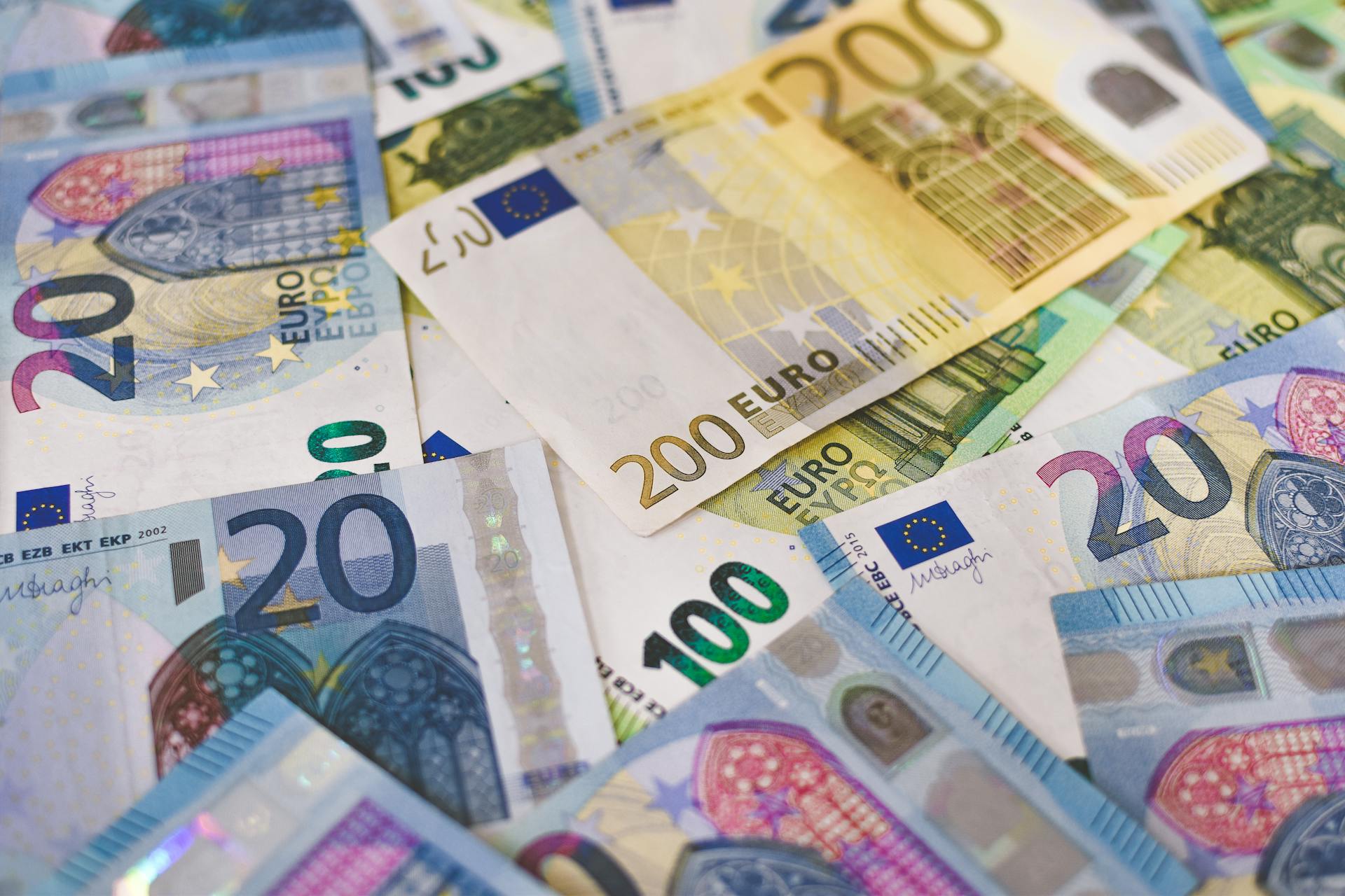 Close-up of various Euro banknotes scattered on a surface, highlighting European currency.