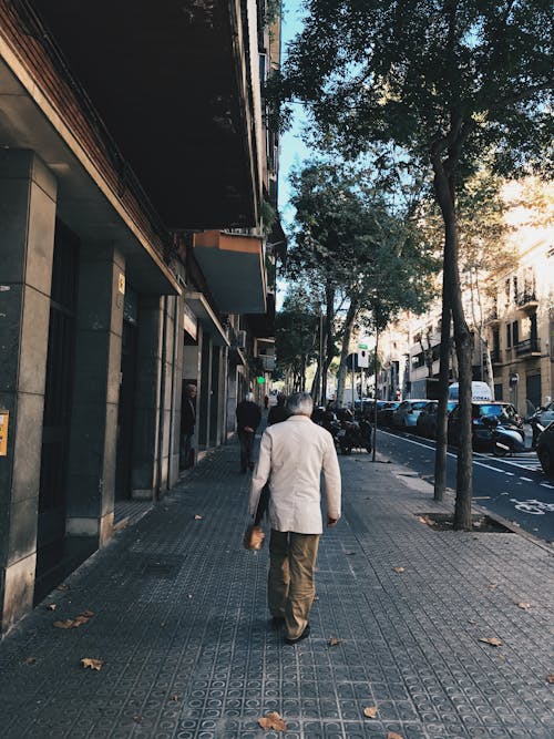 Elderly Man Walking on Sidewalk