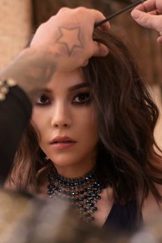 Close-up shot of a model at a hair styling session indoors.