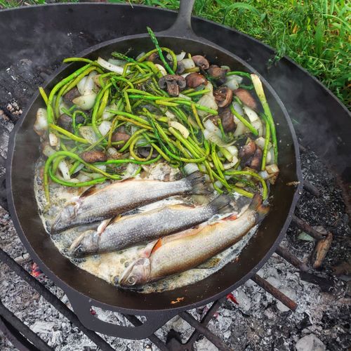 Fish and greens cooked in a pan over embers — photo by Em Everyday Living on Pexels