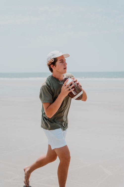 Teenage Boy Holding a Ball at the Beach