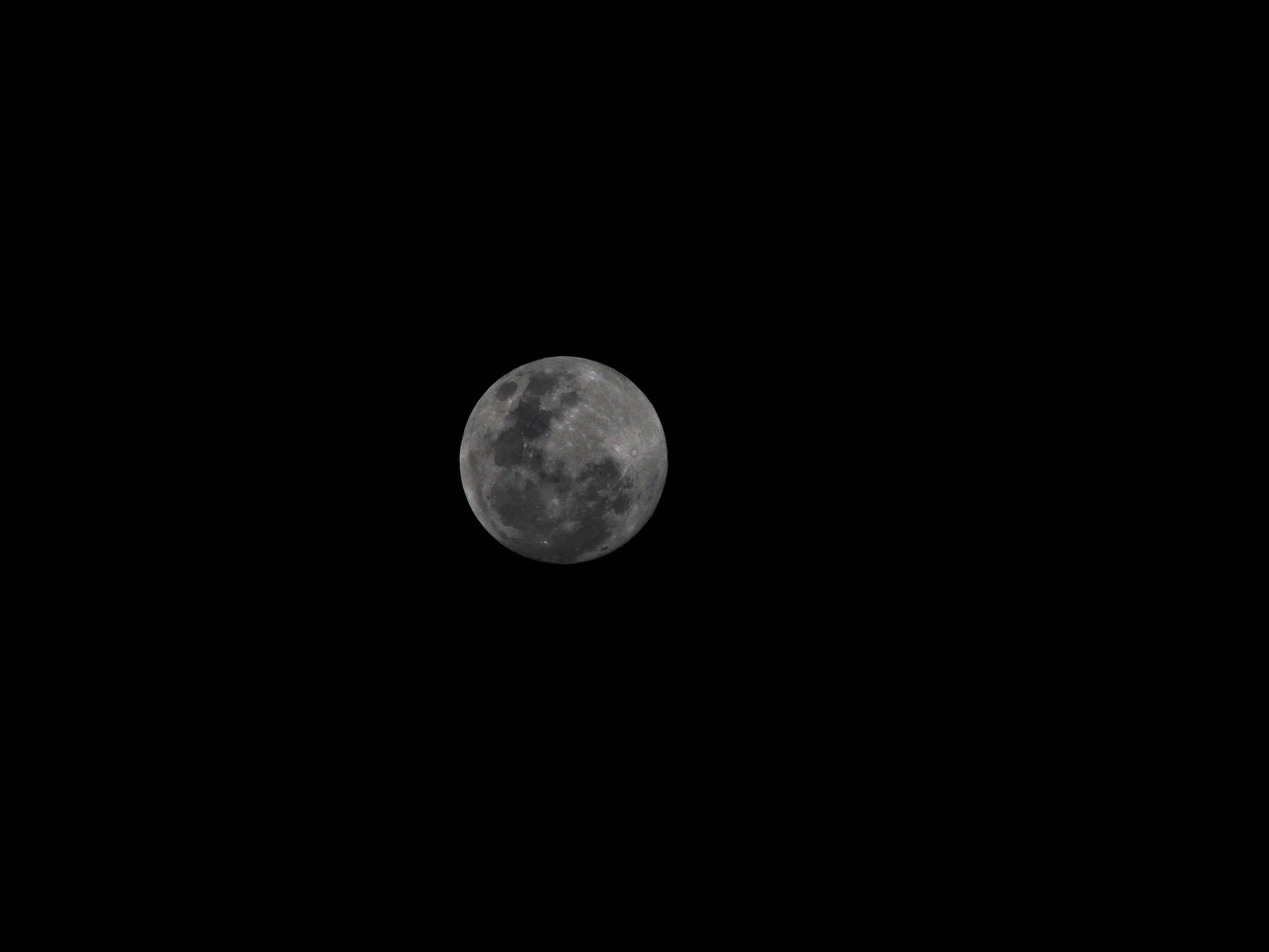 Captivating shot of a full moon against a dark night sky, symbolizing mystery and tranquilly.